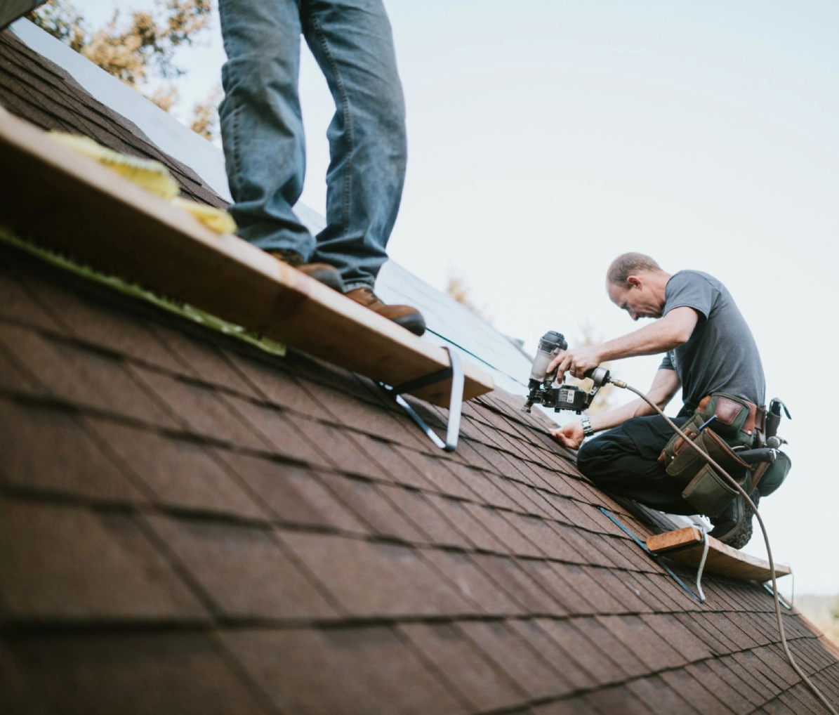 Men installing roof shingles