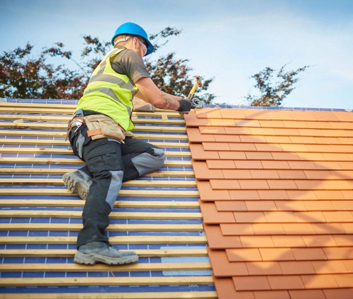 Construction worker laying roof tiles