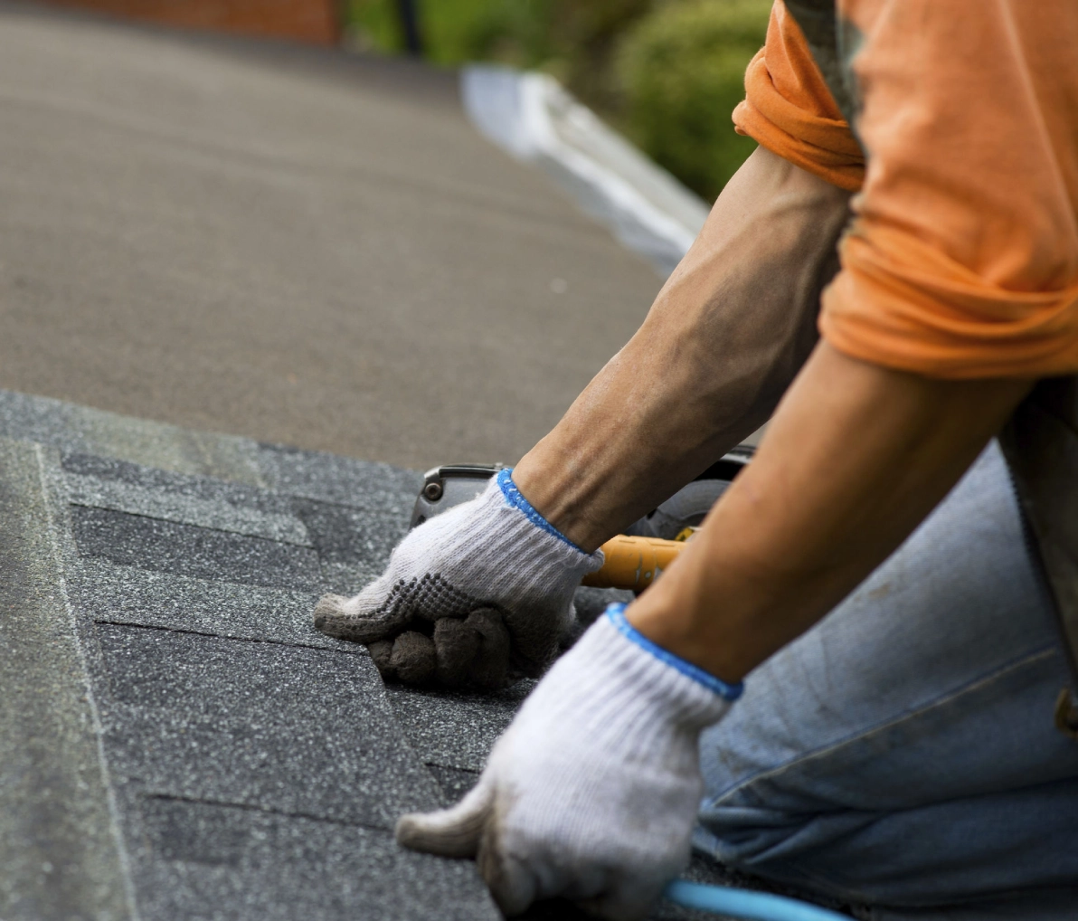 Hands fixing roof shingles