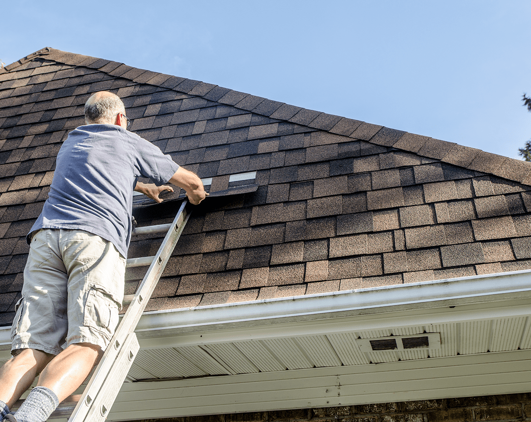 Roof maintenance by worker on ladder