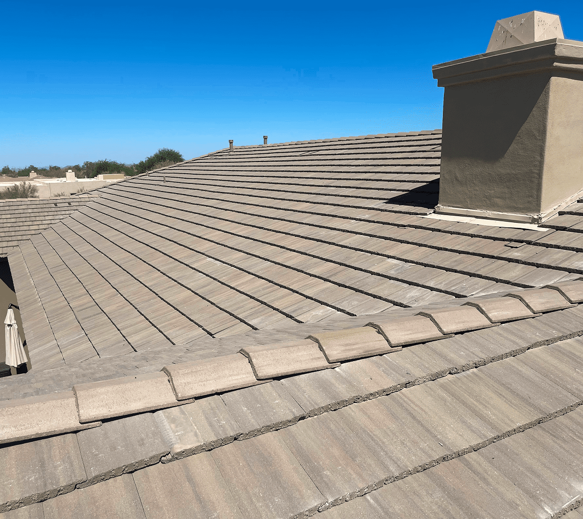 Tiled roof with chimney against clear sky
