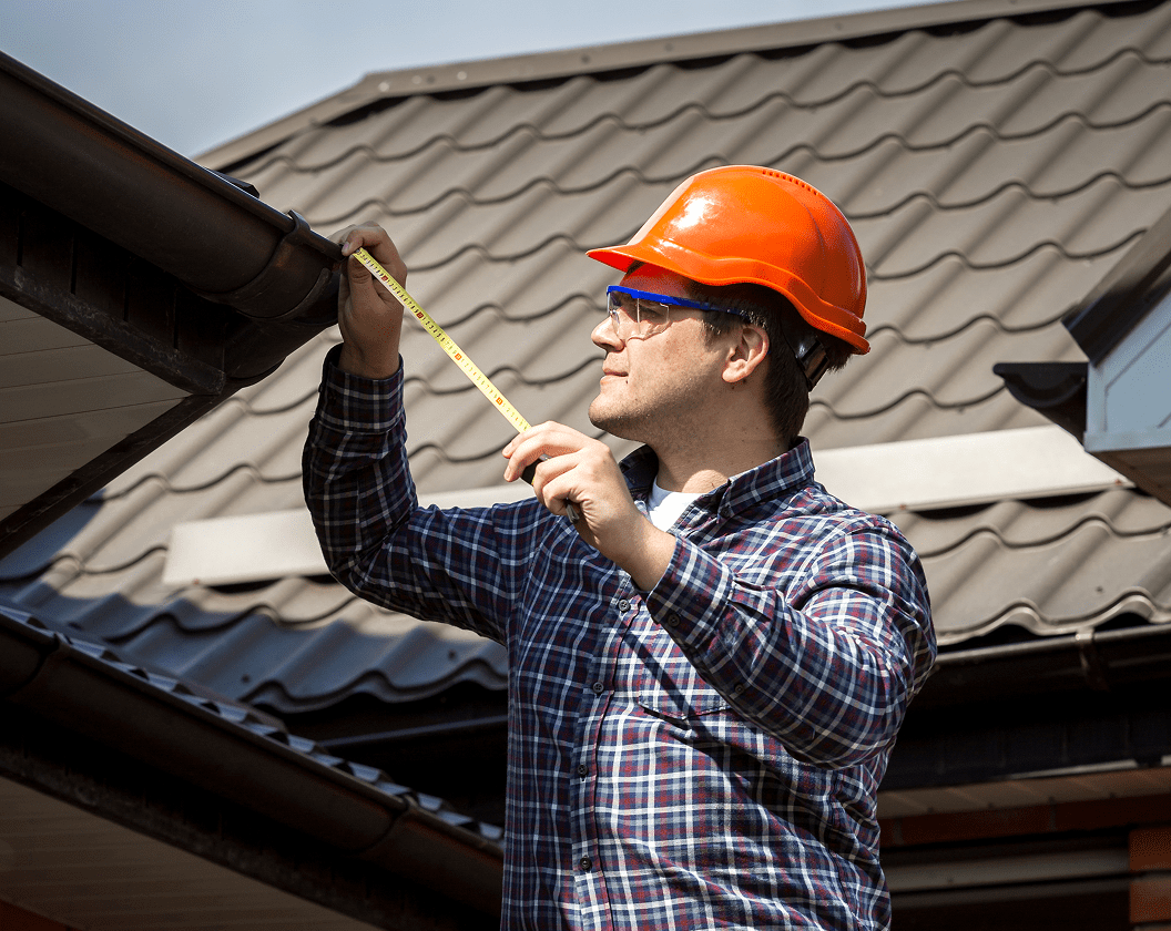 Construction worker assessing roof dimensions