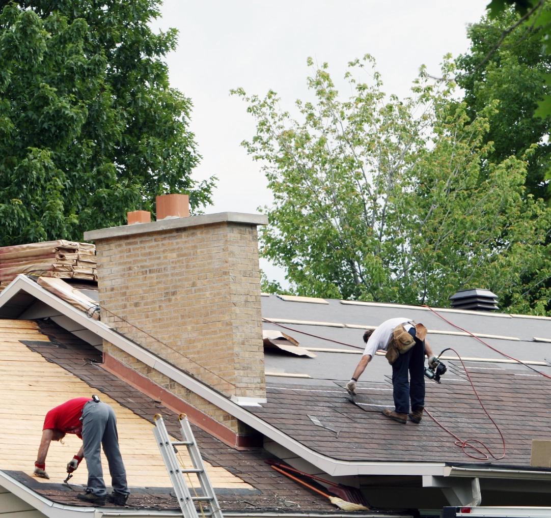 Workers repairing house roof with tools