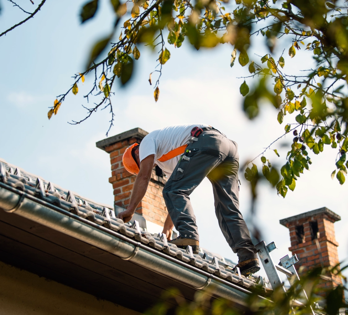 Man inspecting roof shingles and gutters