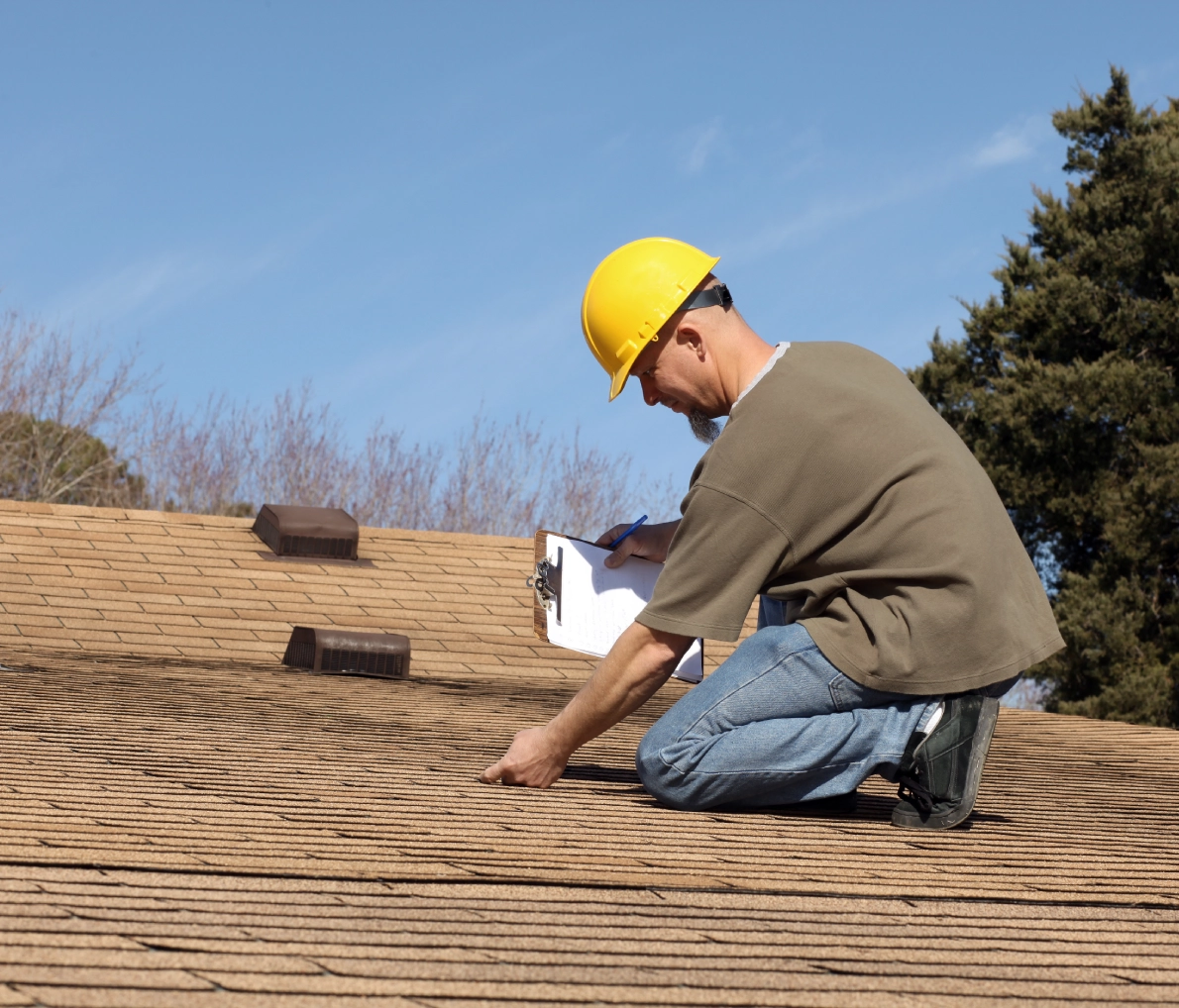 Worker inspecting roof with clipboard
