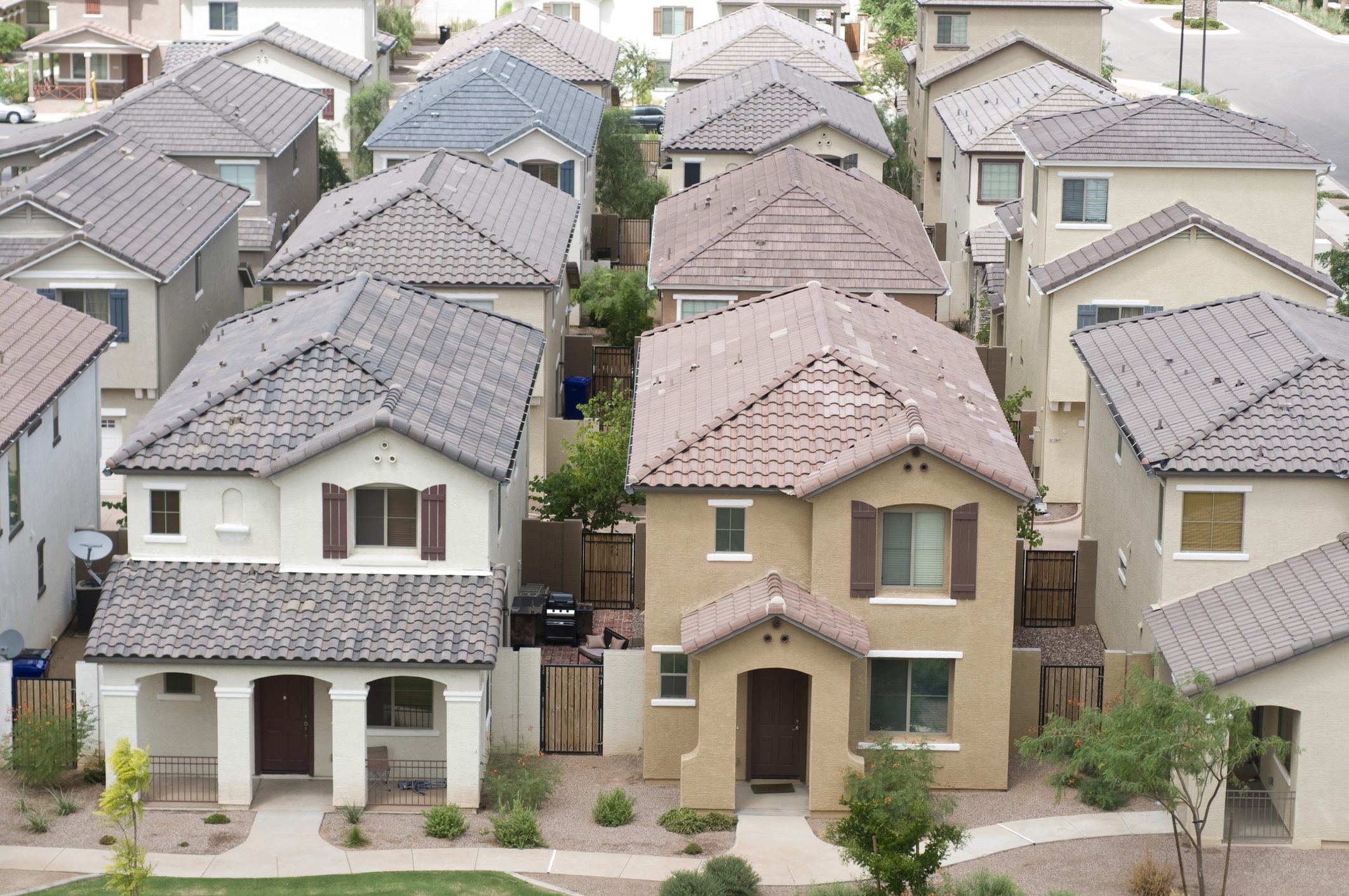 Rows of suburban houses with tiled roofs and small yards.